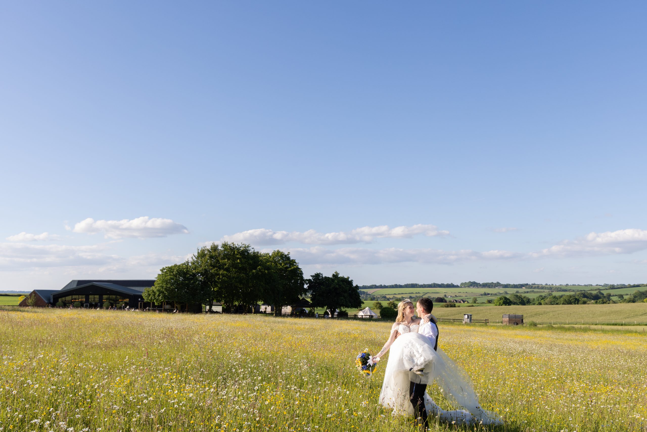 A recently married couple in a field at Wellington Barn